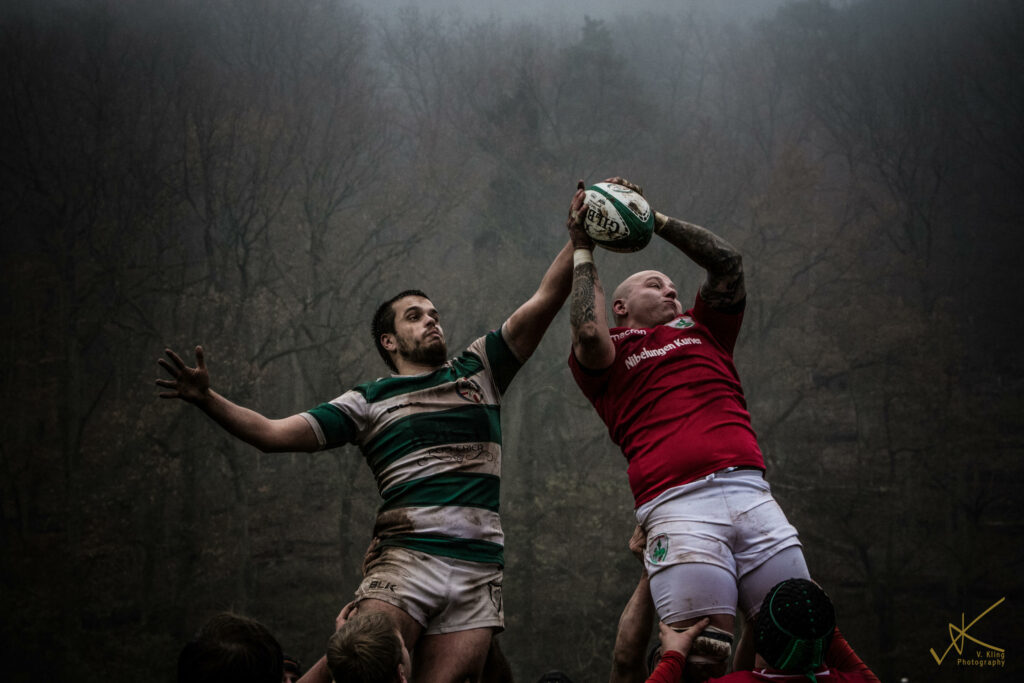 Foto eines Einwurfs. Zwei Spieler werden in die Luft gehoben und versuchen den Ball zu fangen.