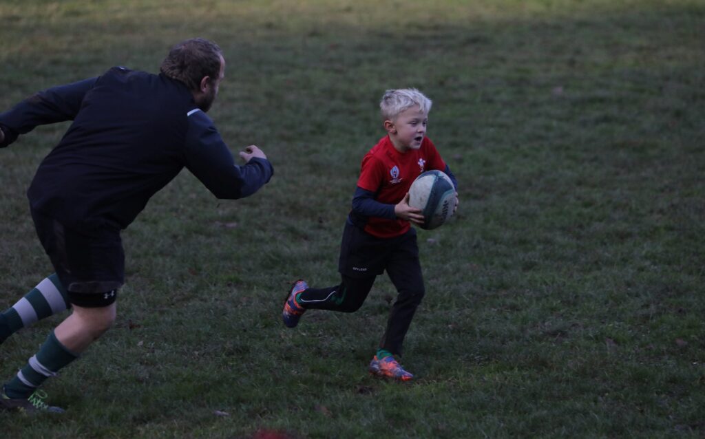 Kind rennt mit Rugbyball